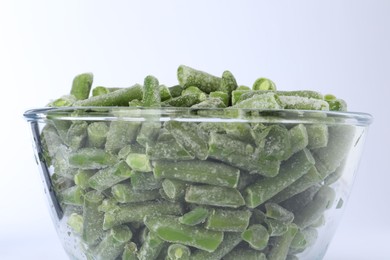 Photo of Frozen green beans in bowl isolated on white