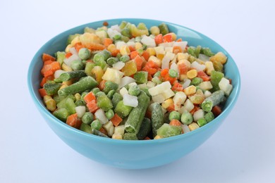 Photo of Mix of frozen vegetables in bowl isolated on white