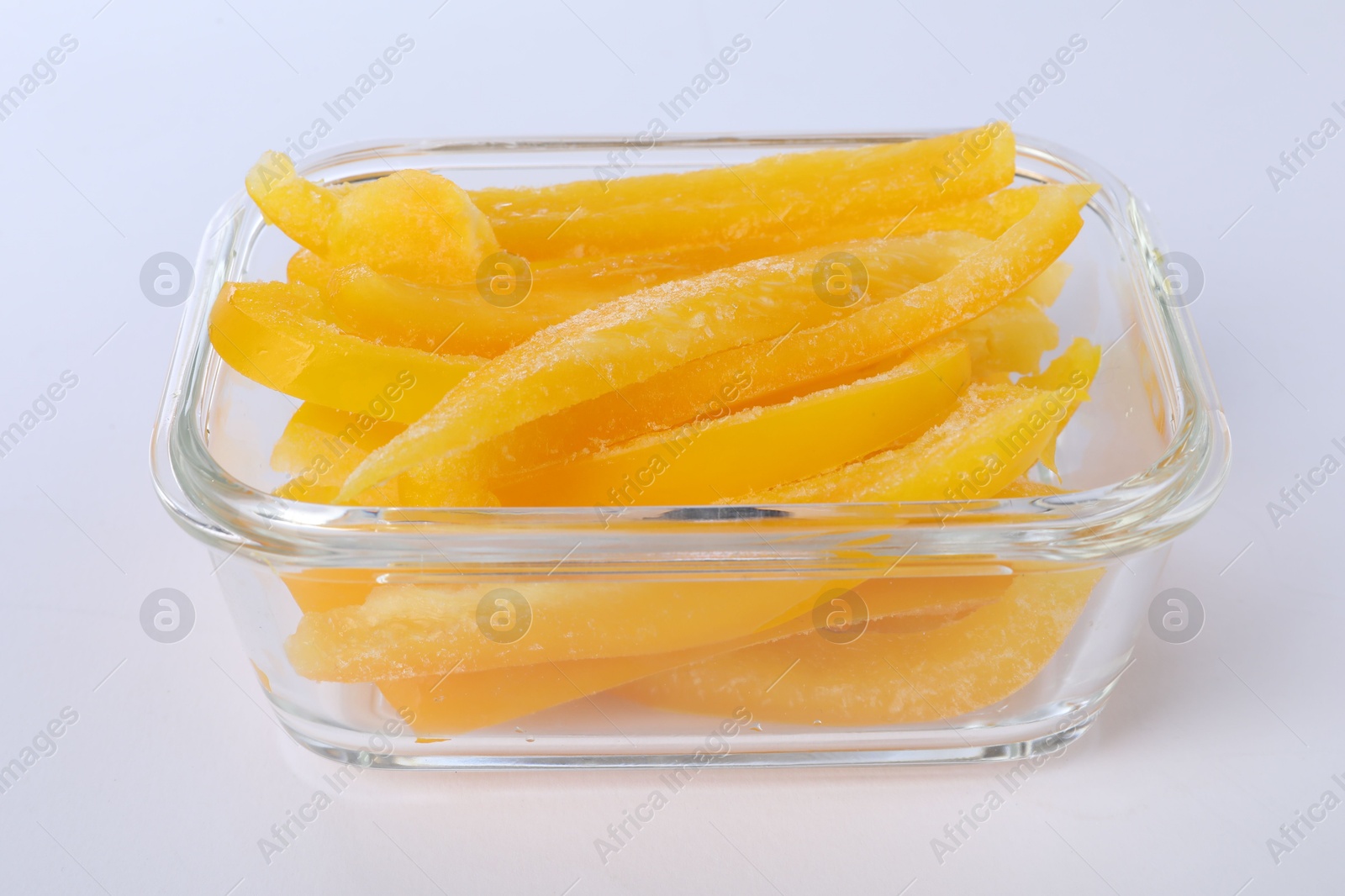 Photo of Pieces of frozen bell peppers in container isolated on white