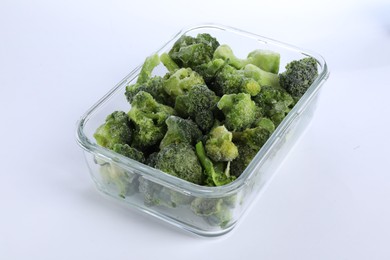 Photo of Frozen broccoli in container isolated on white