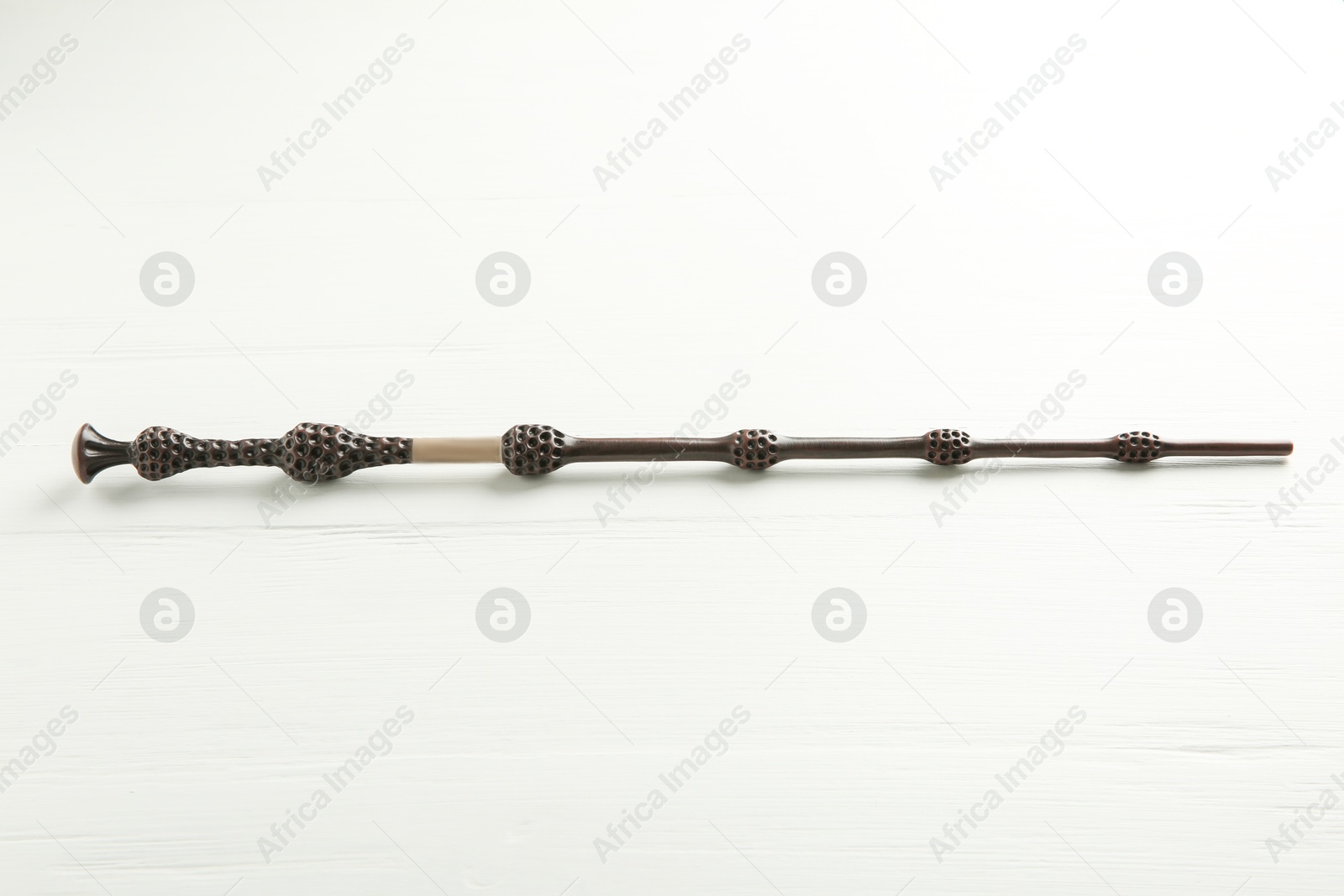 Photo of One old magic wand on white wooden table