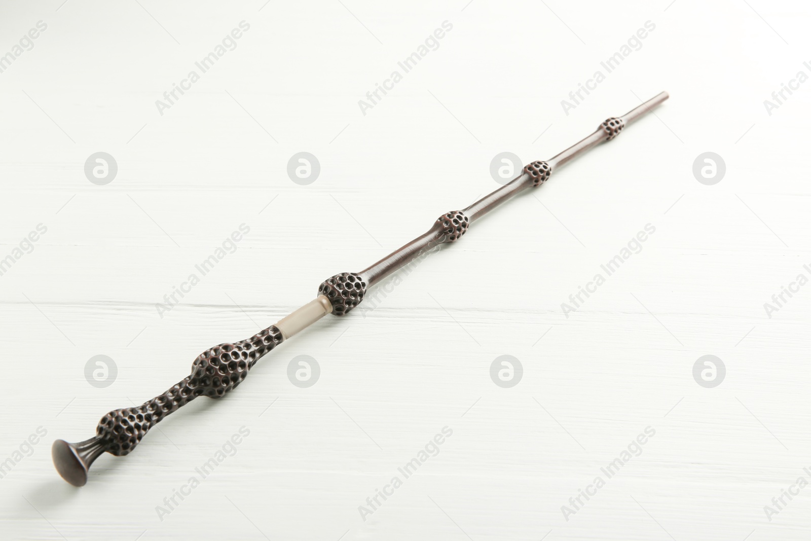 Photo of One old magic wand on white wooden table, closeup