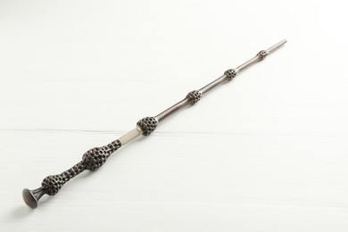 Photo of One old magic wand on white wooden table, closeup