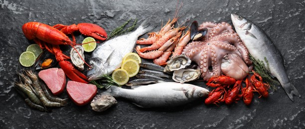 Photo of Fresh fish and different sea food on black table, top view