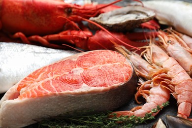 Fresh salmon steak, shrimps and other sea food on table, closeup