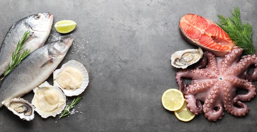 Different sea food on grey table, flat lay. Space for text