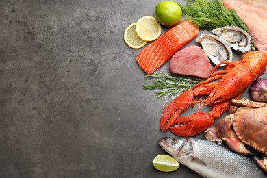 Different sea food on grey table, flat lay. Space for text