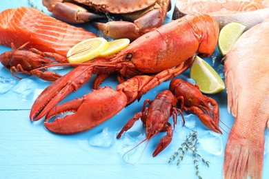 Different sea food on light blue wooden table, closeup