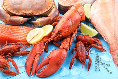 Different sea food on light blue wooden table, closeup