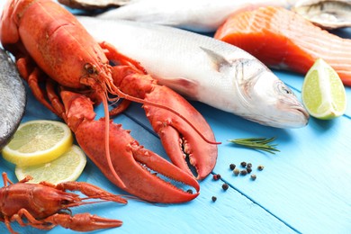 Different sea food on light blue wooden table, closeup