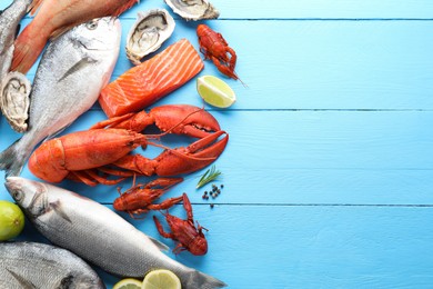 Different sea food on light blue wooden table, flat lay. Space for text