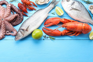 Different sea food on light blue wooden table, flat lay. Space for text