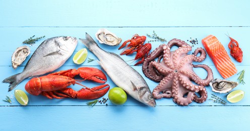 Photo of Different sea food on light blue wooden table, flat lay