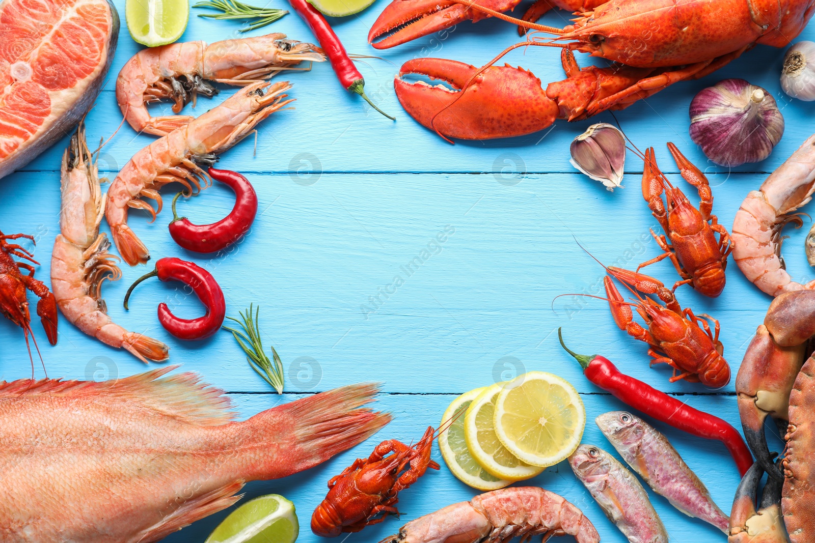 Photo of Frame of different sea food on light blue wooden table, flat lay. Space for text