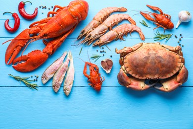 Photo of Different sea food on light blue wooden table, flat lay