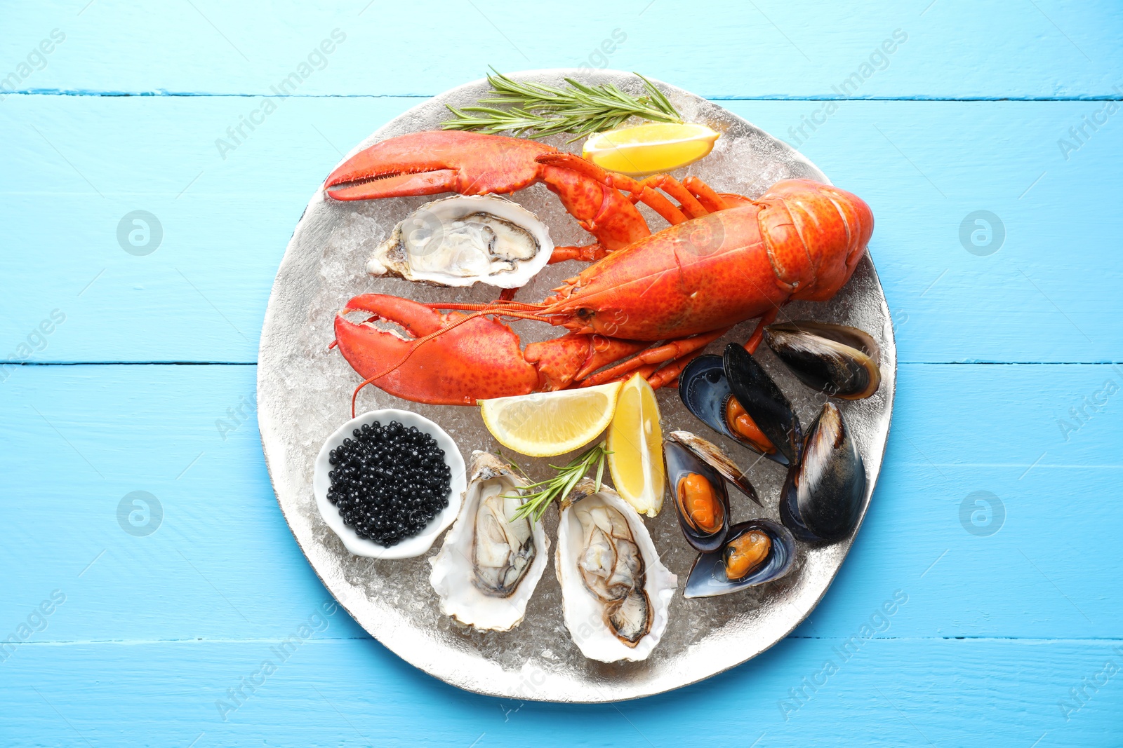 Photo of Many different sea food on light blue wooden table, top view