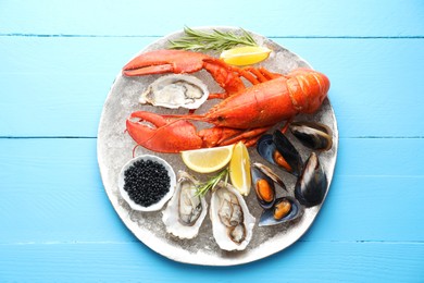 Many different sea food on light blue wooden table, top view