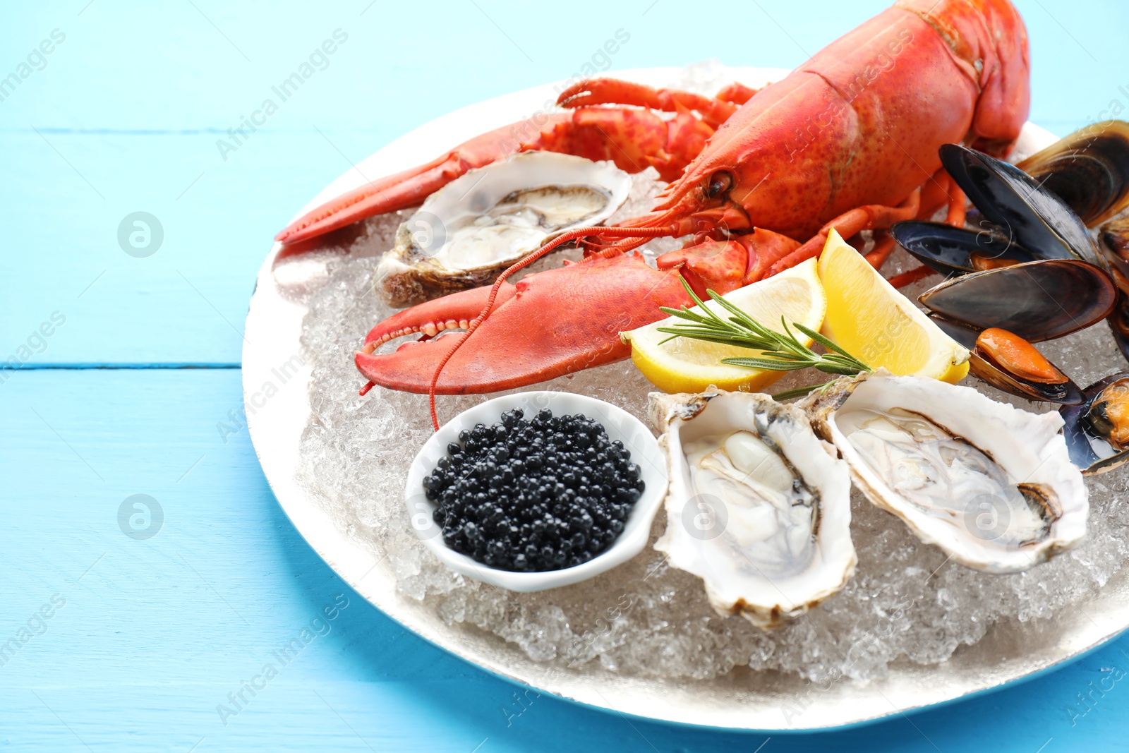 Photo of Many different sea food on light blue wooden table, closeup