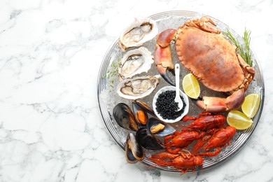 Many different sea food on white marble table, top view. Space for text