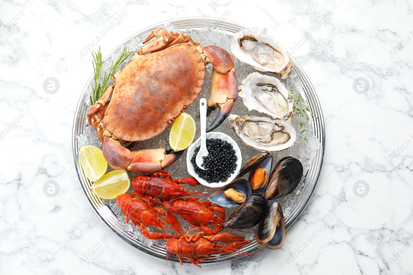 Photo of Many different sea food on white marble table, top view