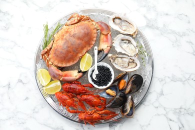 Many different sea food on white marble table, top view