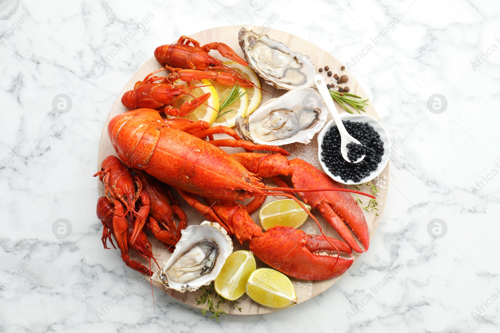 Photo of Many different sea food on white marble table, top view