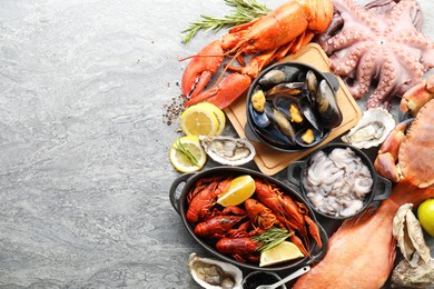 Many different sea food on grey table, top view. Space for text