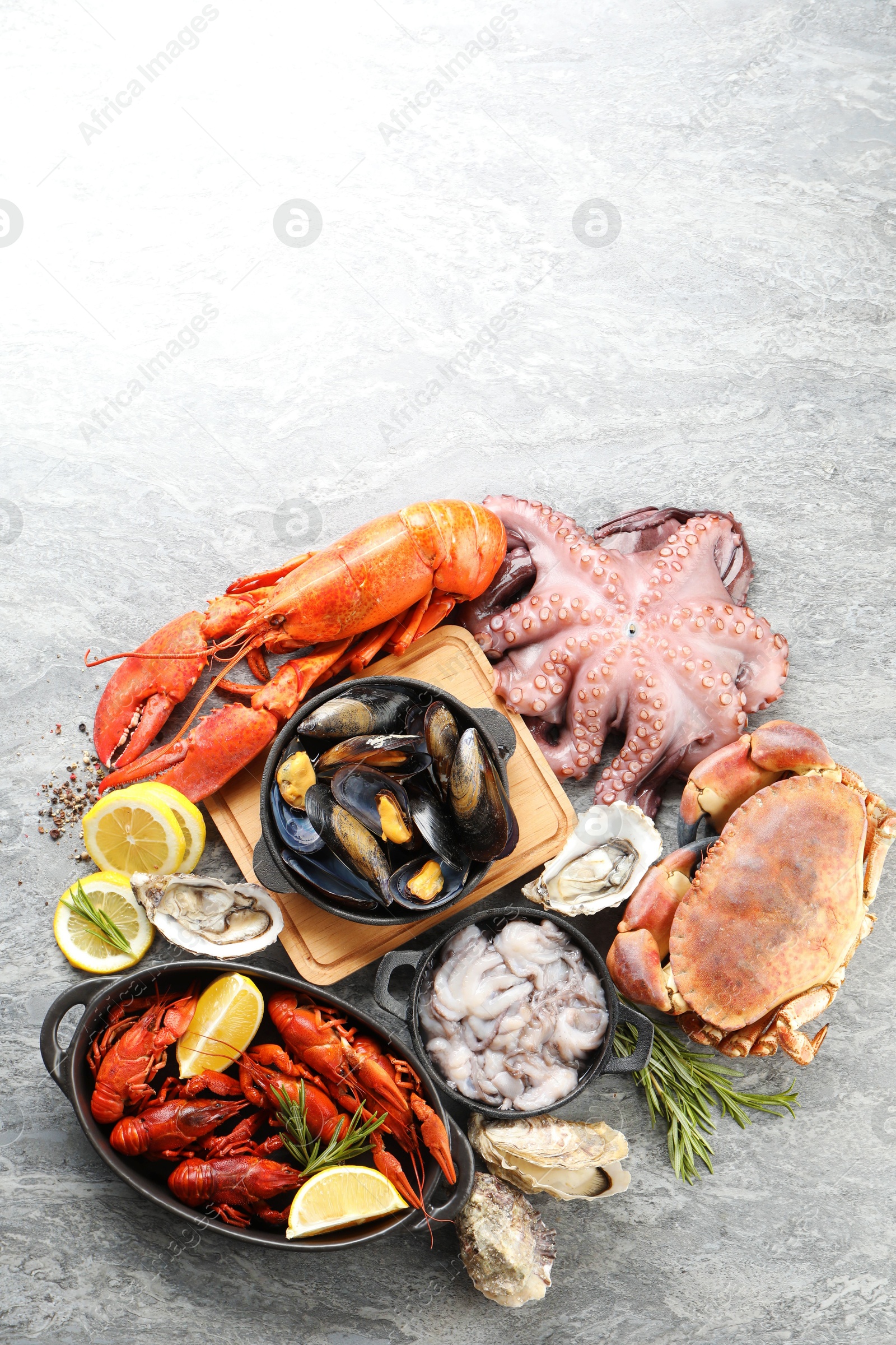 Photo of Many different sea food on grey table, top view