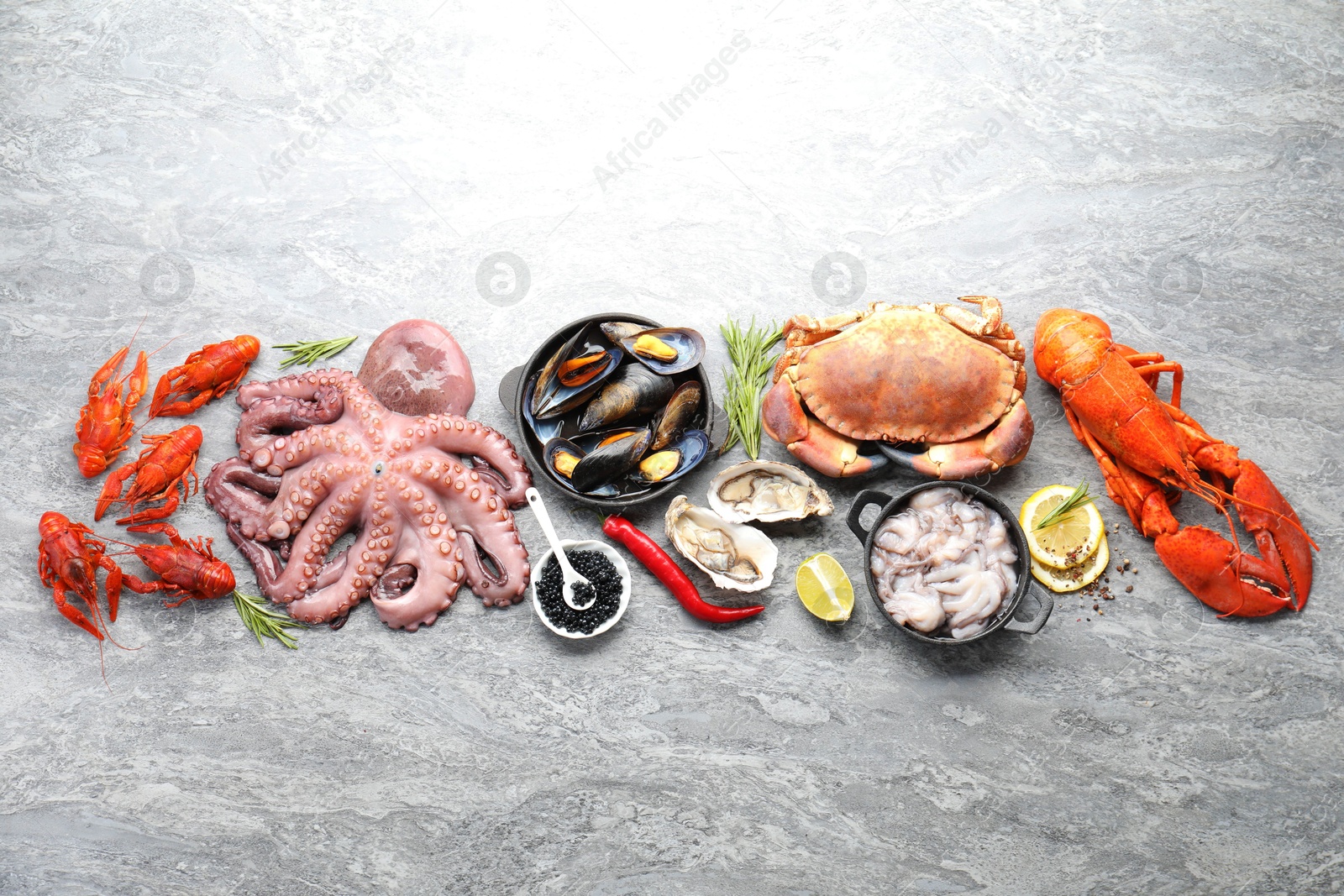 Photo of Many different sea food on grey table, top view