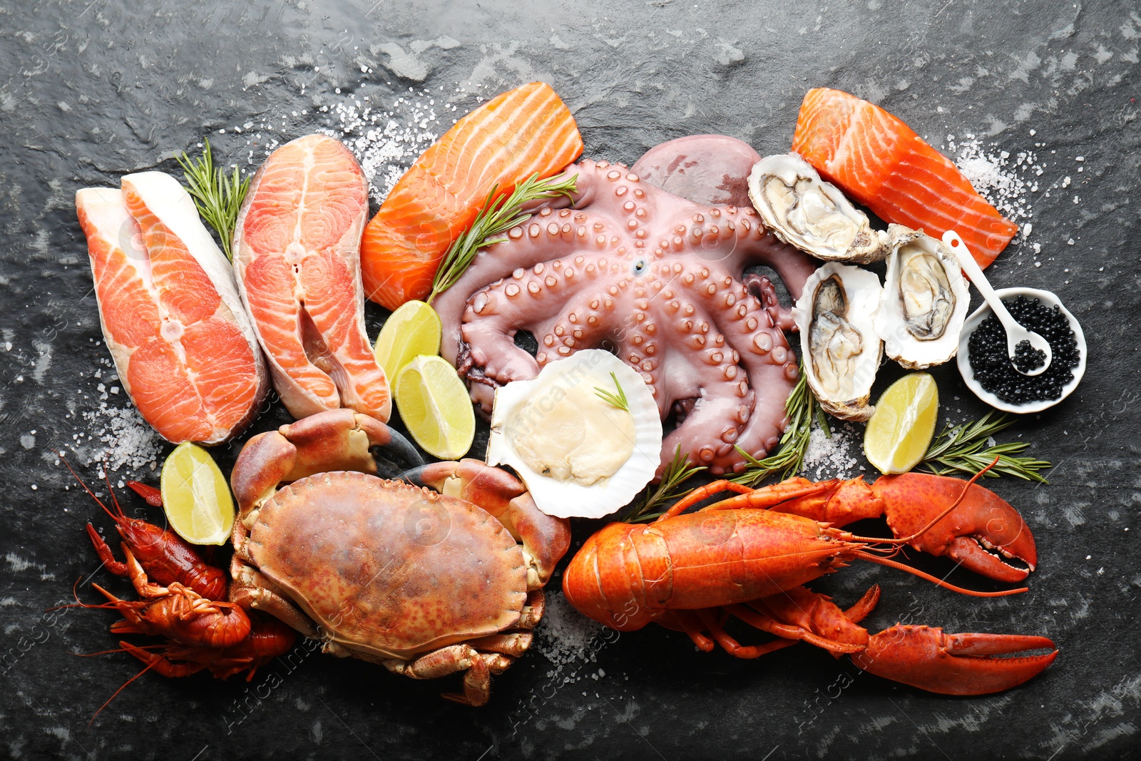 Photo of Many different sea food on dark table, top view