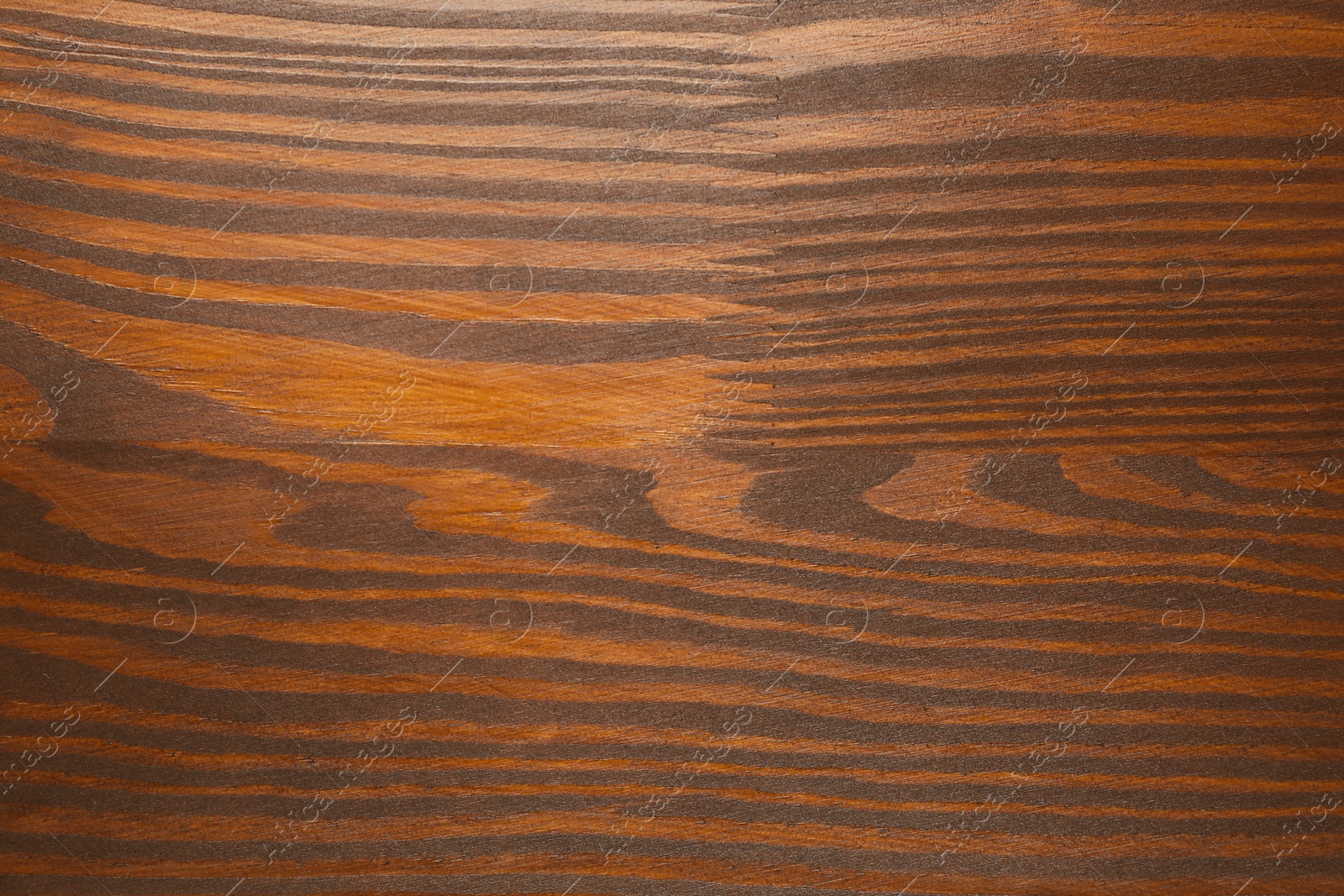 Photo of Applying walnut wood stain. Texture of wooden surface as background, top view