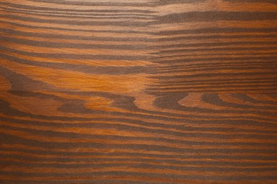 Applying walnut wood stain. Texture of wooden surface as background, top view