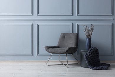 Photo of Stylish stool, chair and vase near light grey wall indoors, space for text