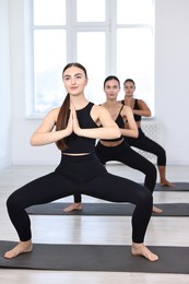 Group of people practicing yoga on mats in class