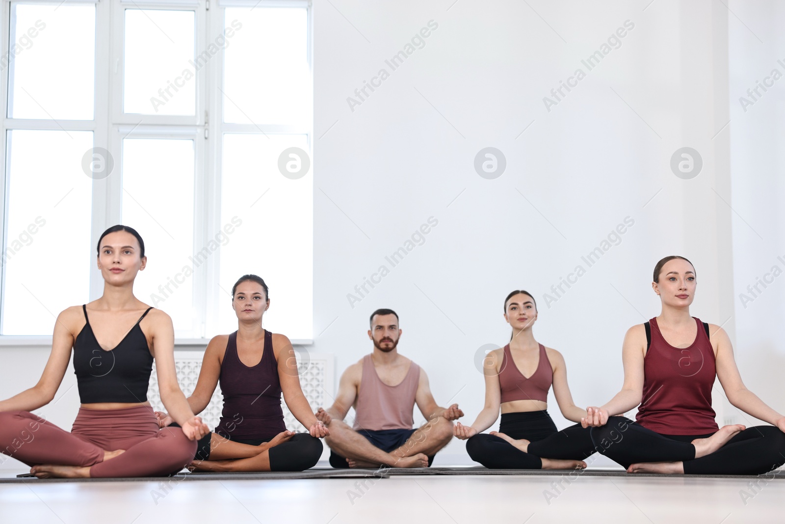 Photo of Group of people meditating on mats in yoga class