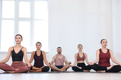 Group of people meditating on mats in yoga class