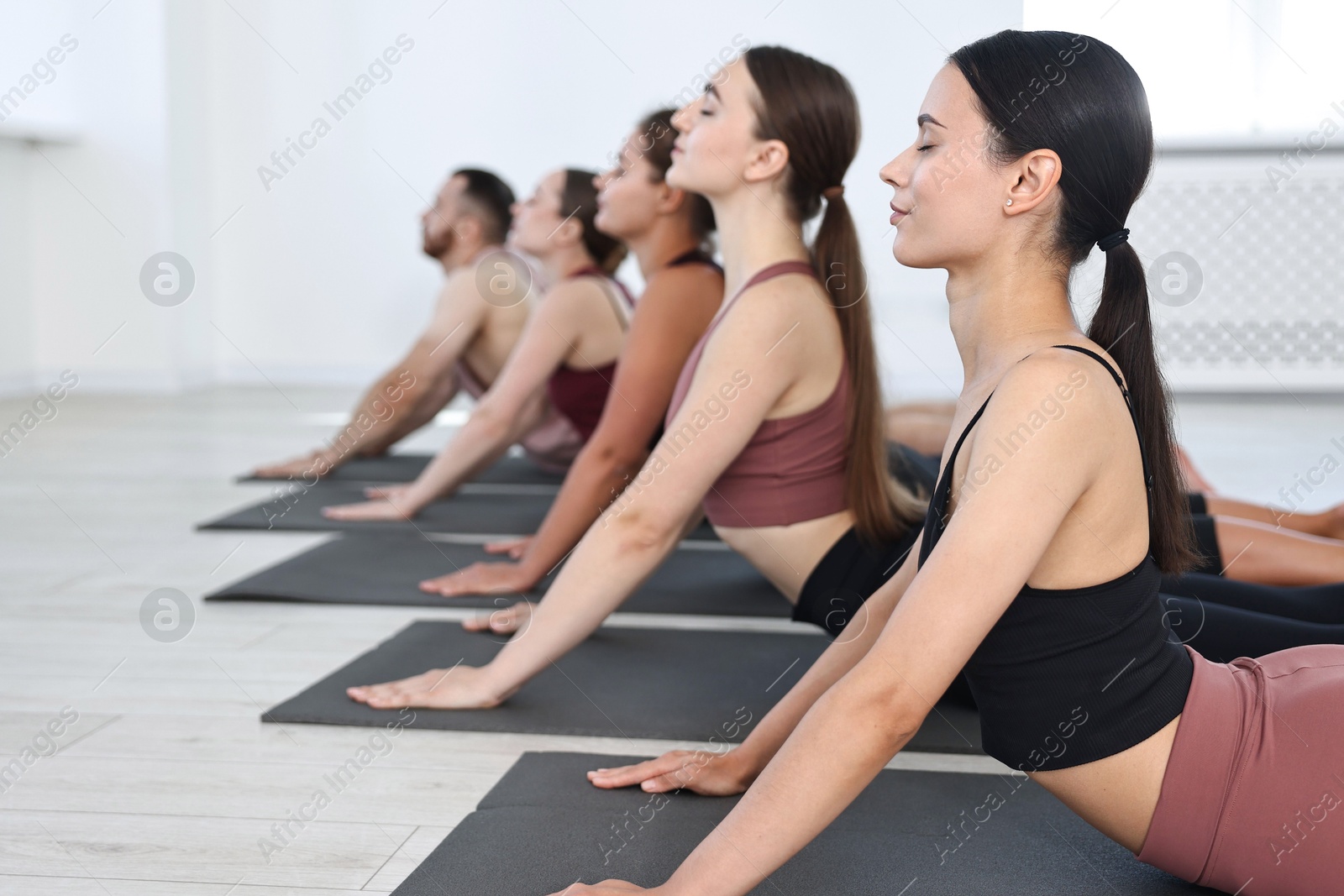 Photo of Group of people practicing yoga on mats in class