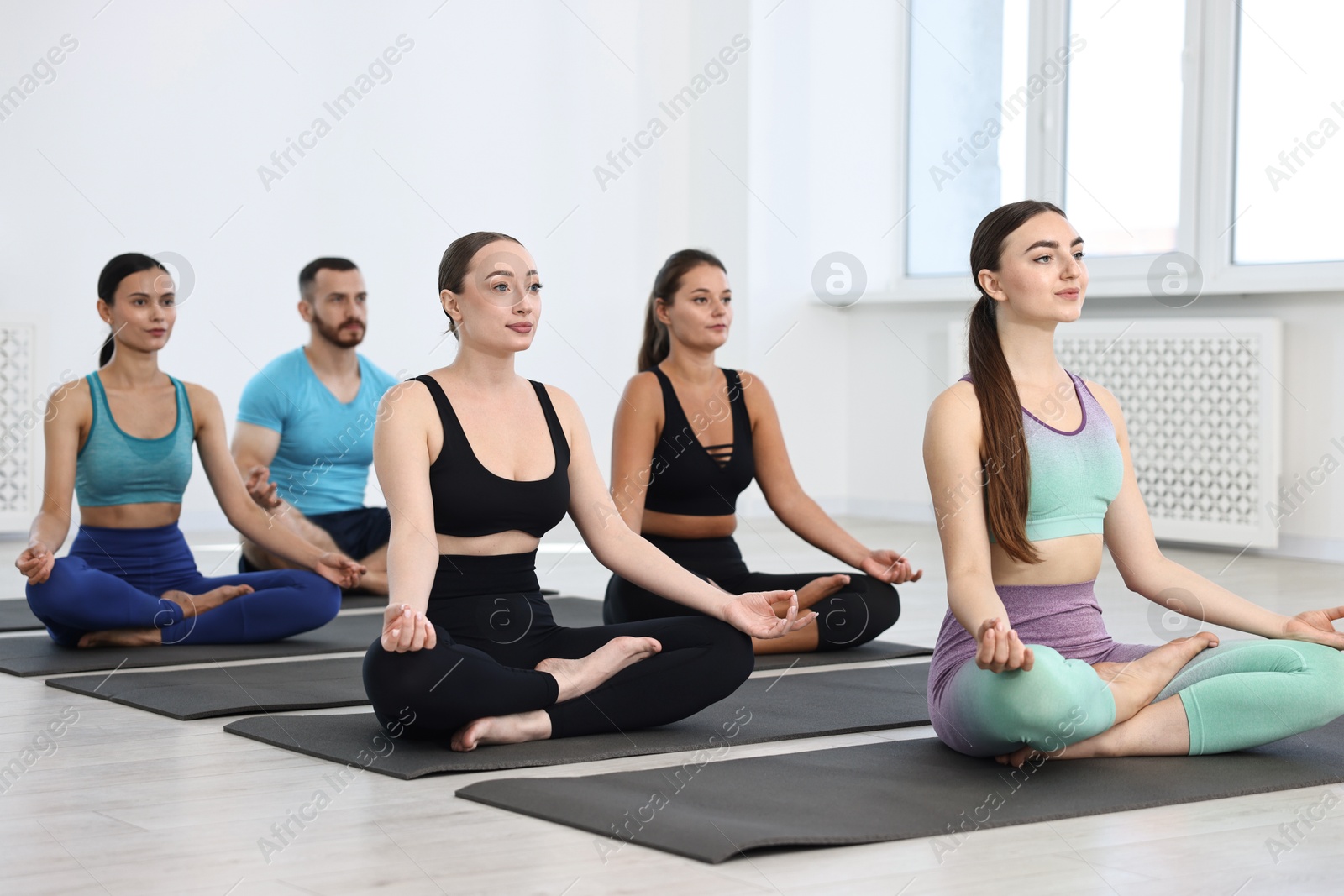 Photo of Group of people meditating on mats in yoga class