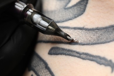 Photo of Woman making tattoo with machine, macro view