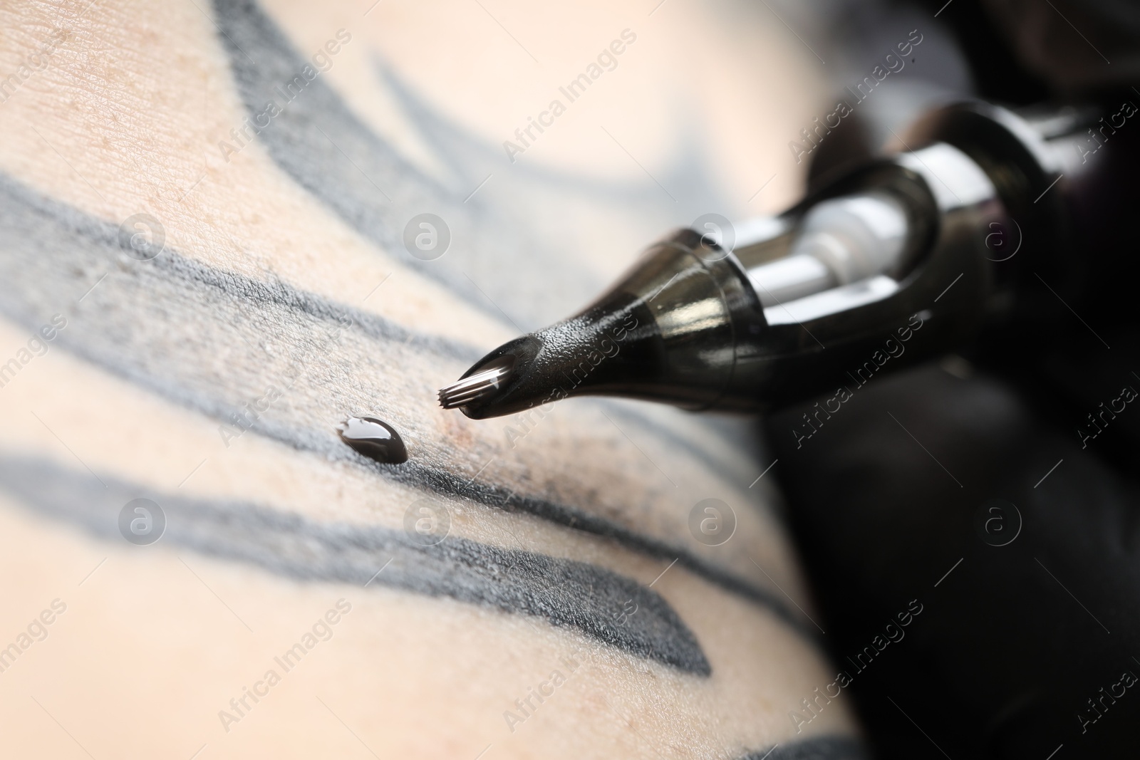 Photo of Woman making tattoo with machine, macro view