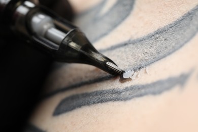 Photo of Woman making tattoo with machine, macro view