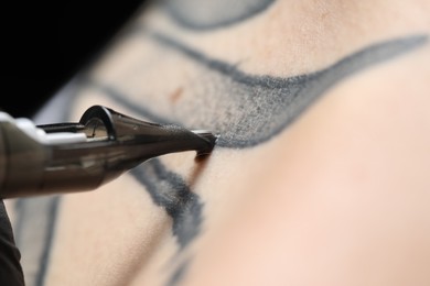 Woman making tattoo with machine, macro view