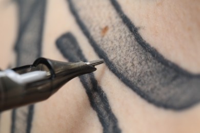 Photo of Woman making tattoo with machine, macro view