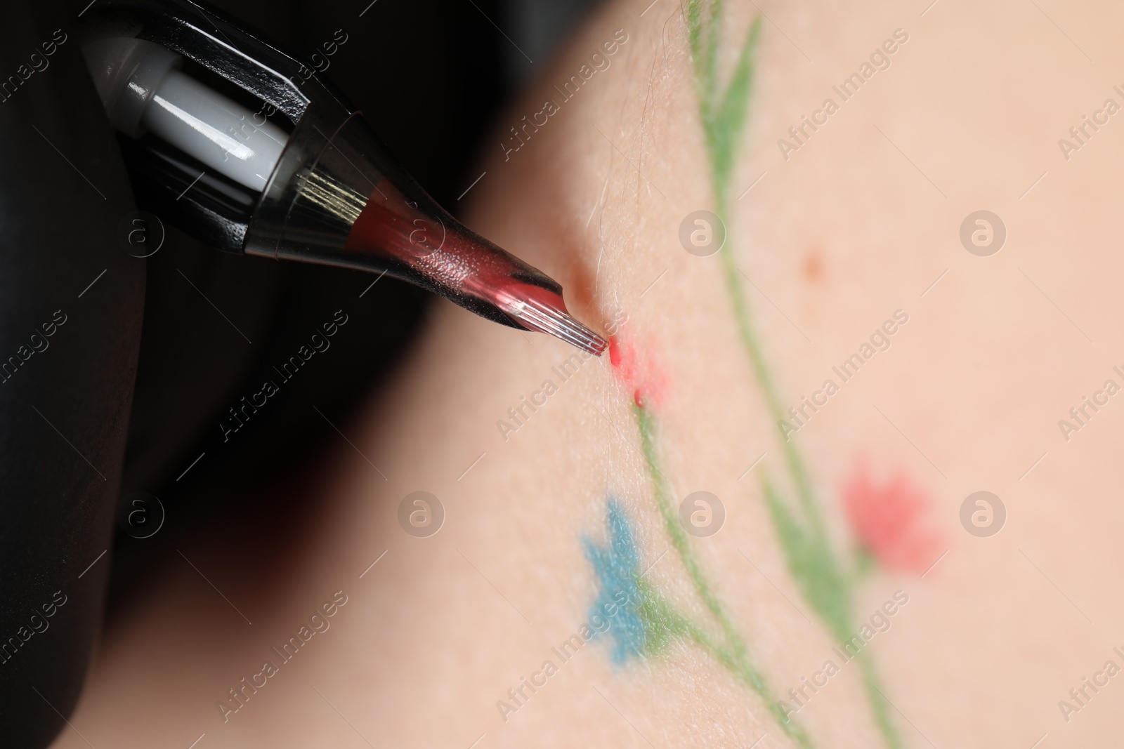 Photo of Woman making tattoo with machine, macro view