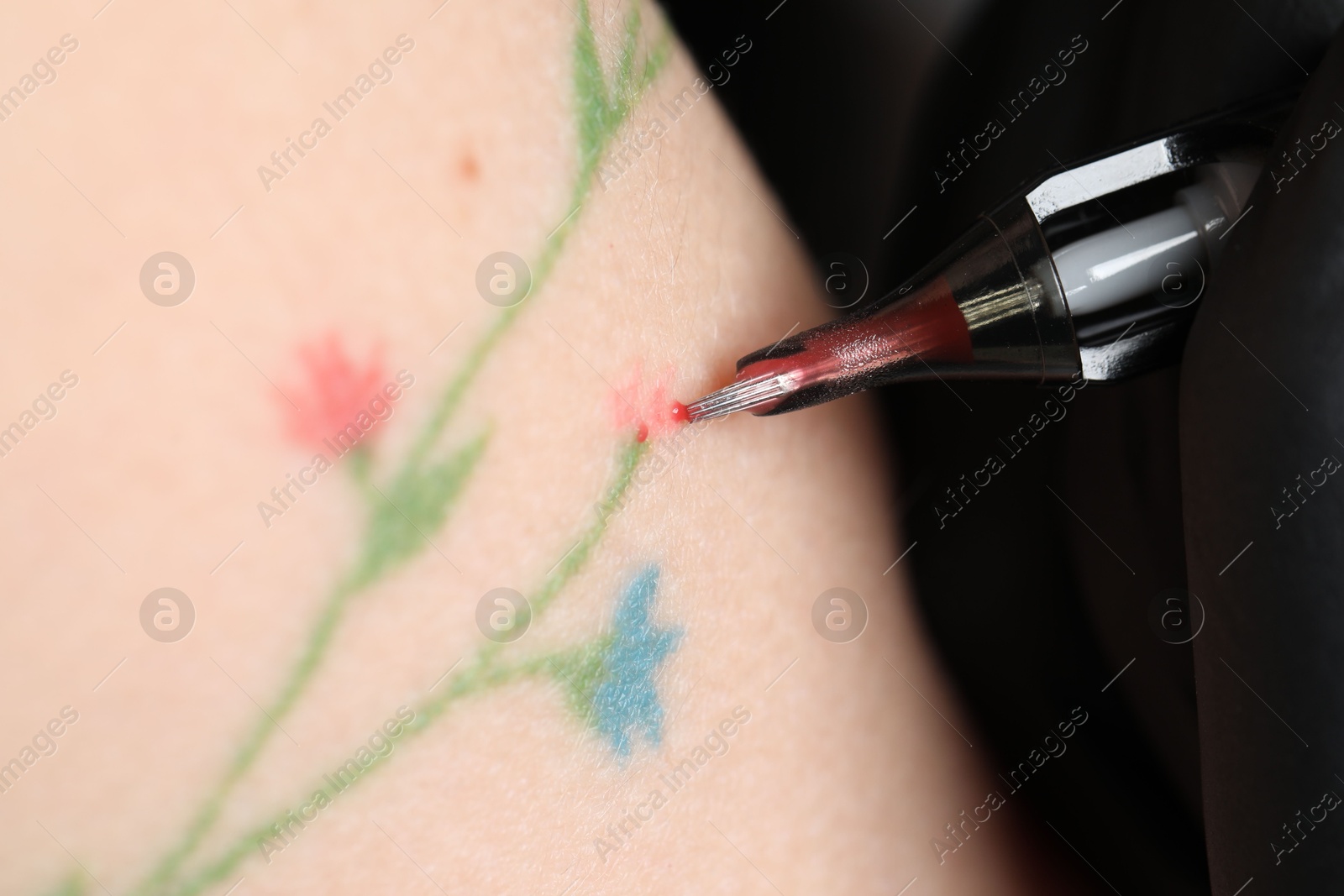 Photo of Woman making tattoo with machine, macro view