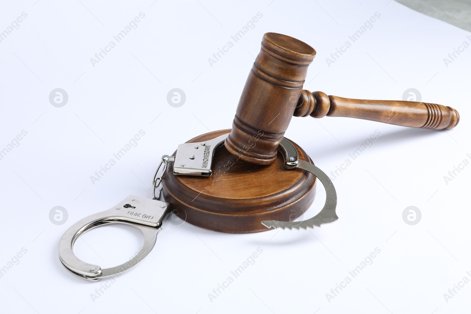 Photo of Handcuffs and judge's gavel isolated on white