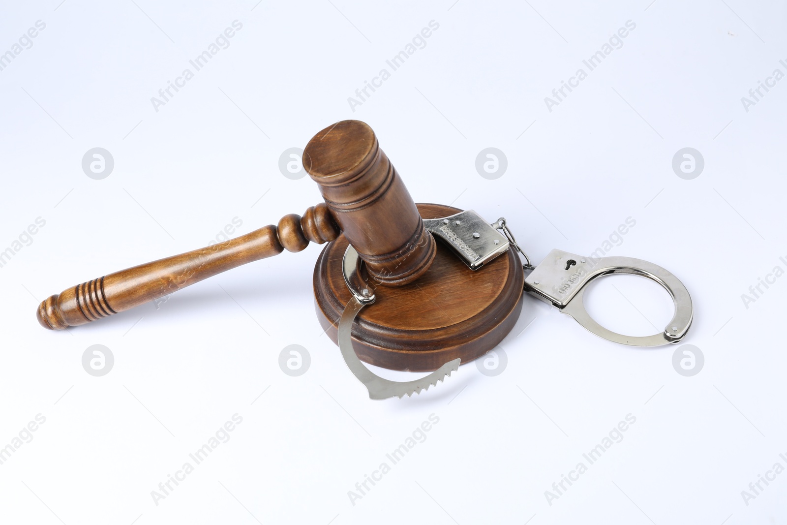 Photo of Handcuffs and judge's gavel isolated on white