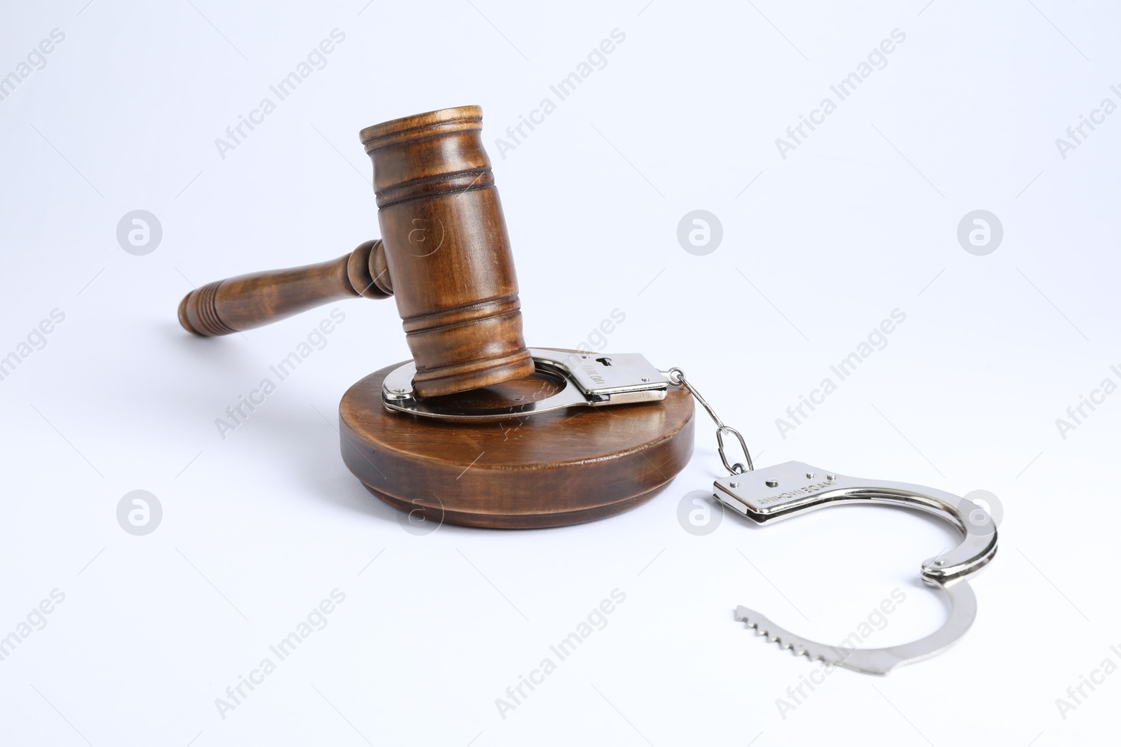 Photo of Handcuffs and judge's gavel isolated on white