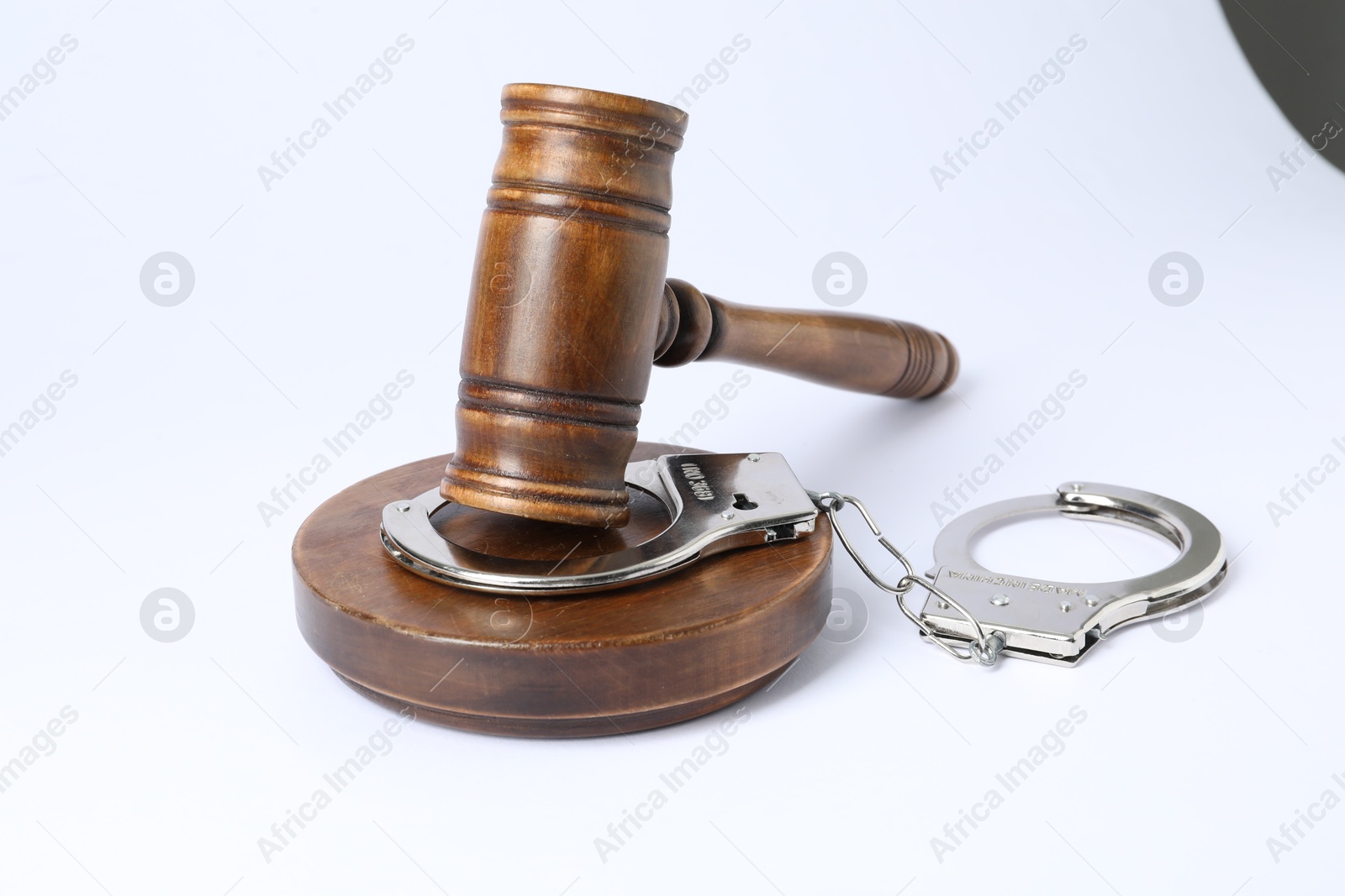 Photo of Handcuffs and judge's gavel isolated on white