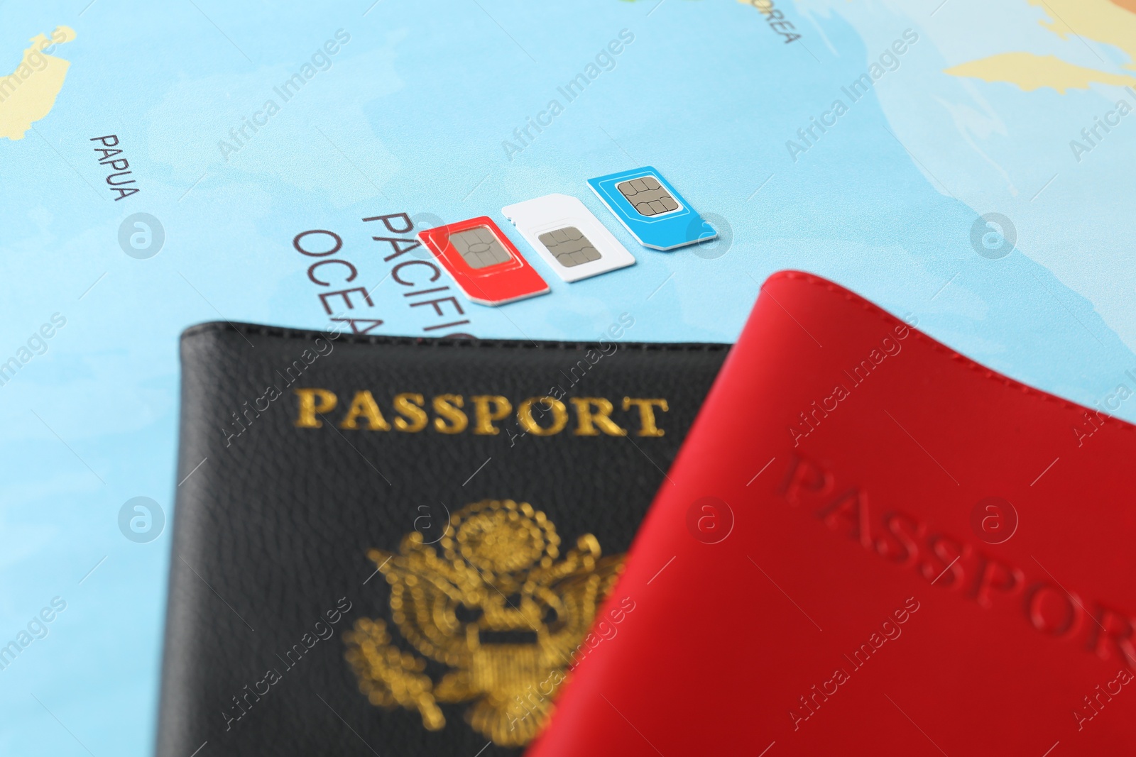 Photo of Passports and SIM cards on world map, closeup